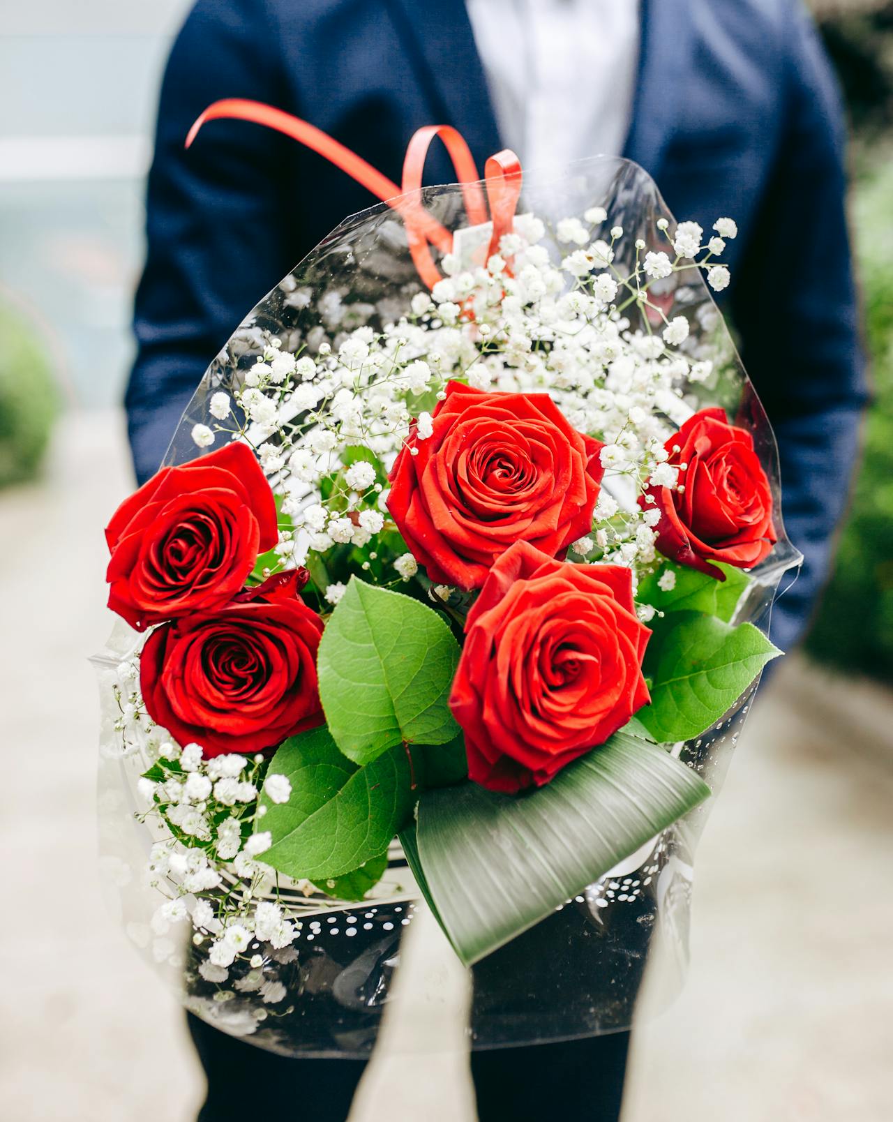 A man holding a bouquet of red roses | Source: Pexels