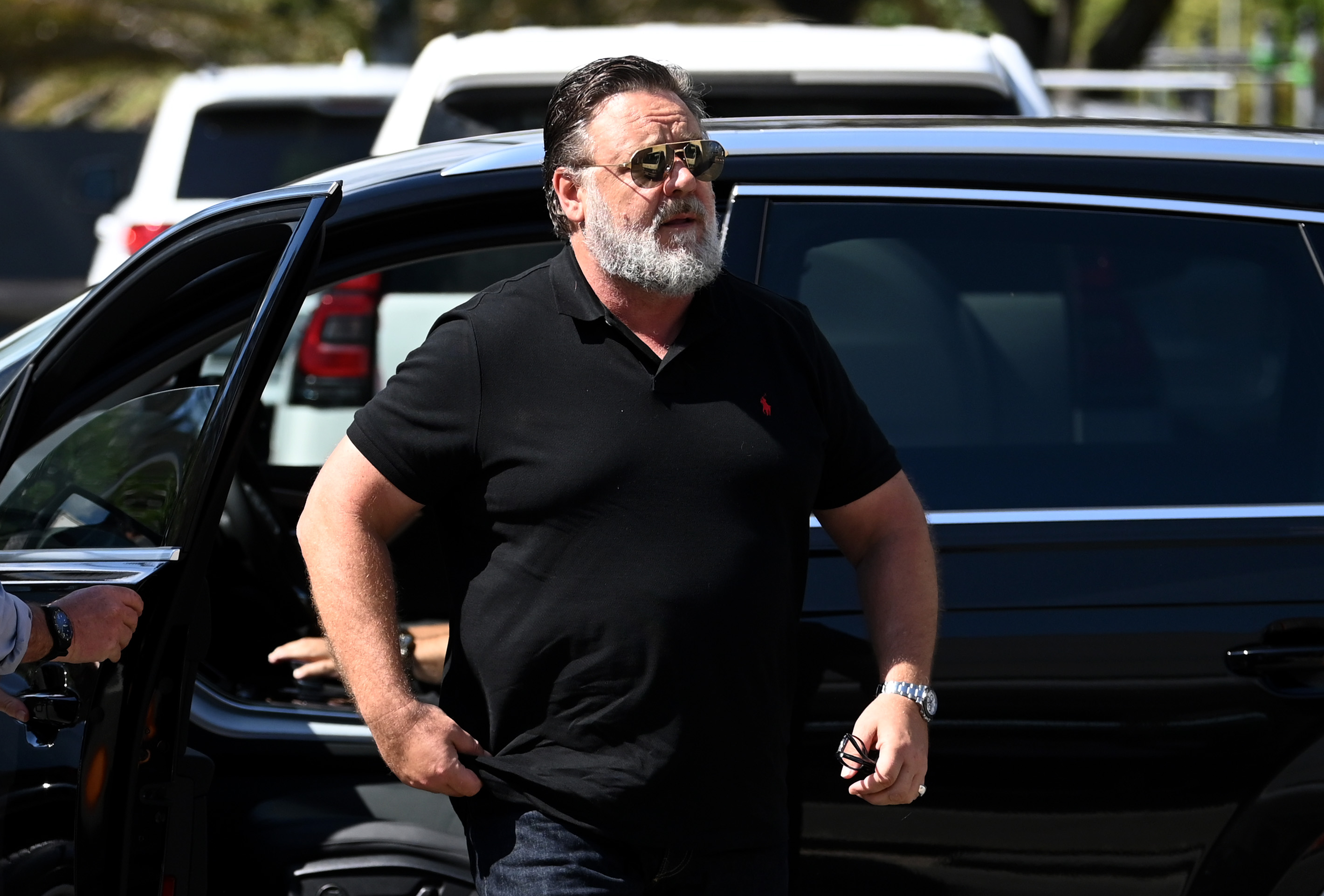 Russell Crowe arrived at a media call on January 28, 2023, in Burleigh Heads, Australia, dressed in a fitted black polo and jeans. With a full white beard, aviator sunglasses, and solid build, the actor appeared confident and casual ahead of the weight-loss transformation that would soon make headlines.