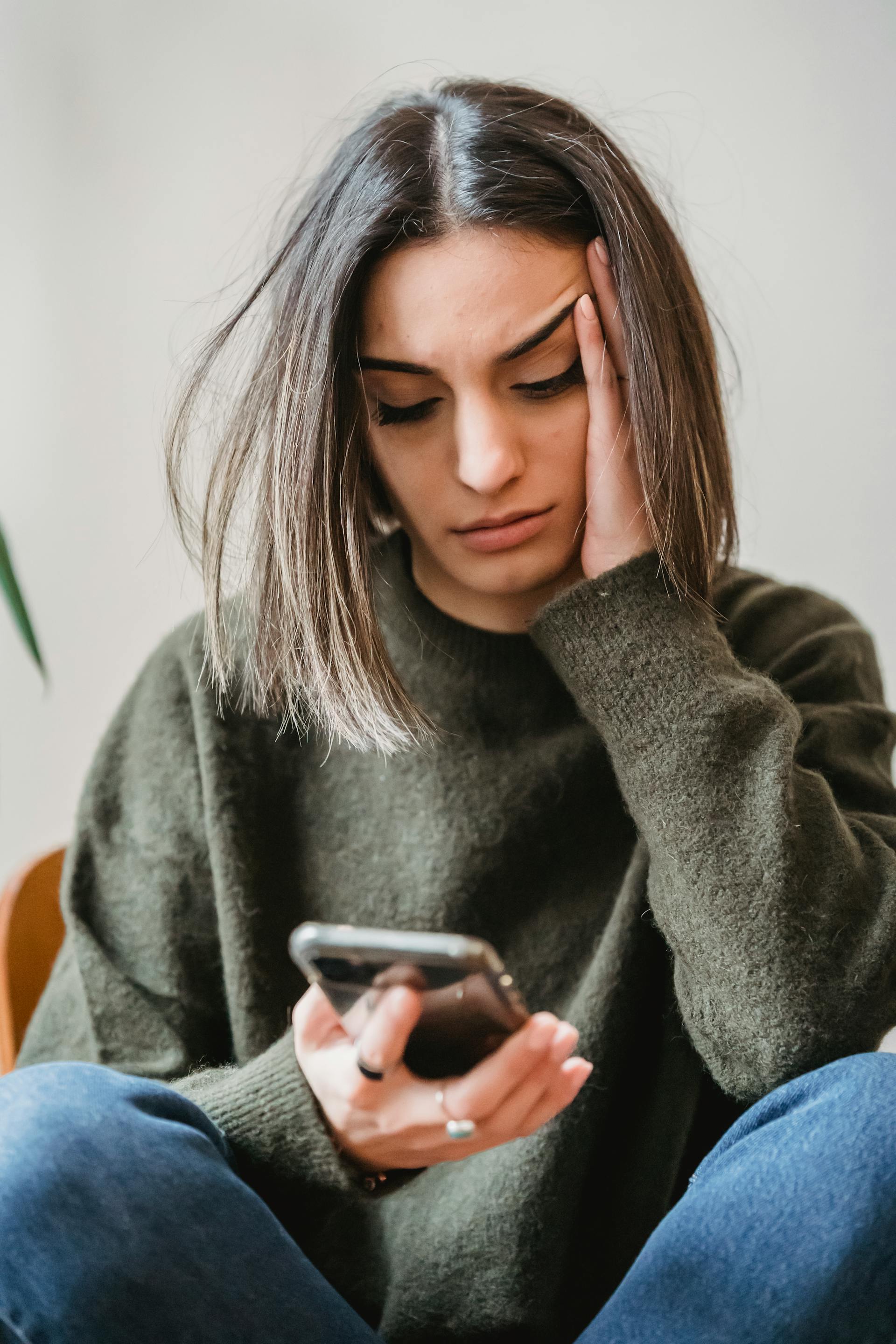 A woman staring down at her phone | Source: Pexels