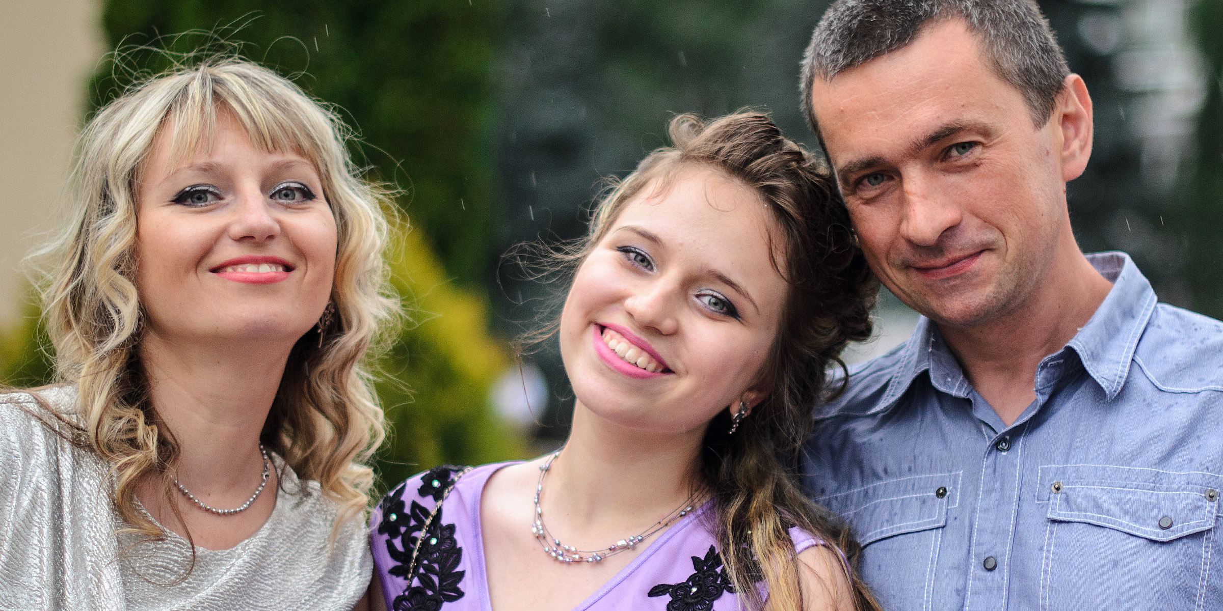 A young woman with her parents | Source: Shutterstock
