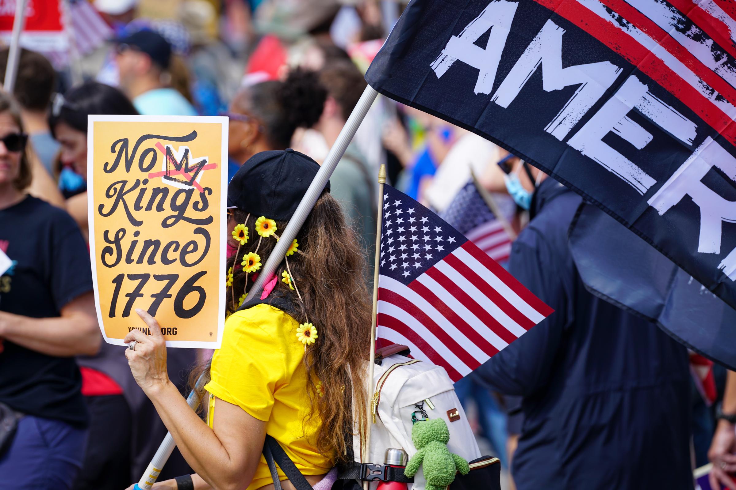 Demonstrators hold protest signs during a march from the Atlanta Civic Center to the Georgia State Capitol on October 18, 2025, in Atlanta, Georgia | Source: Getty Images
