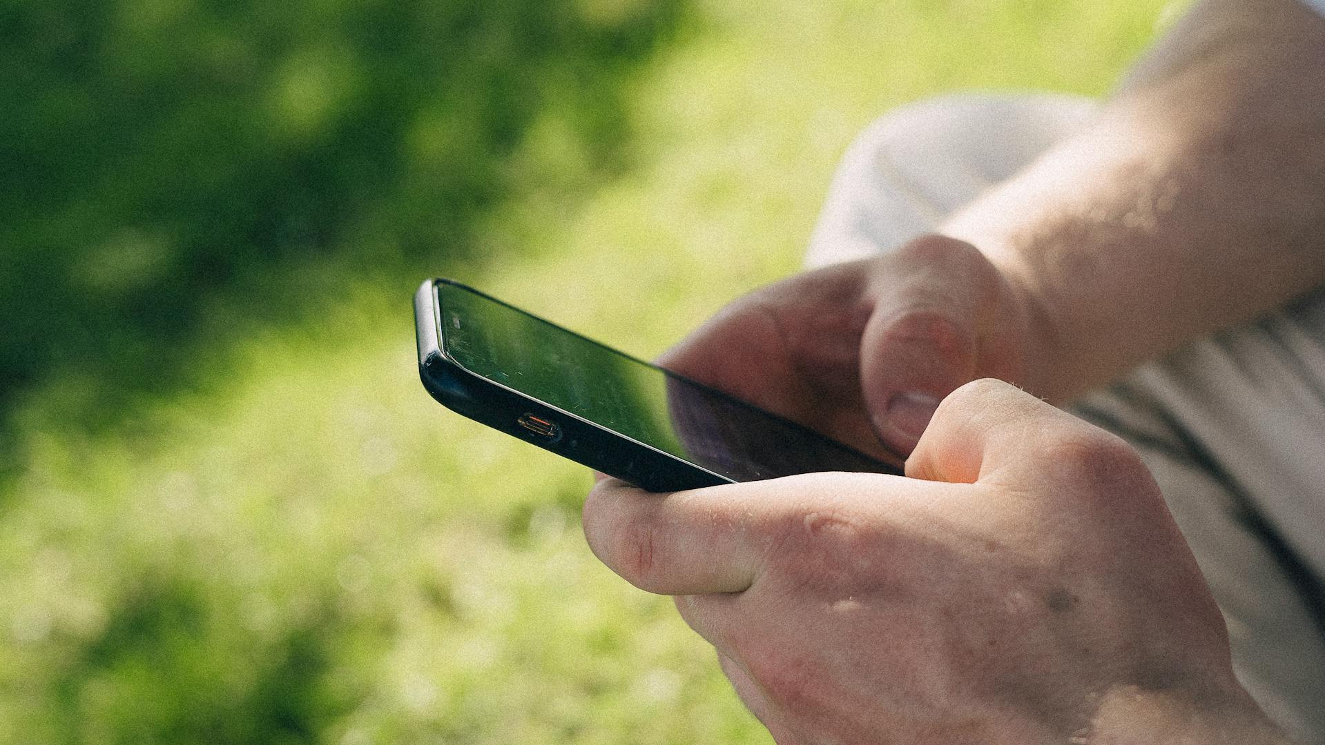A man using his phone outdoors | Source: no source