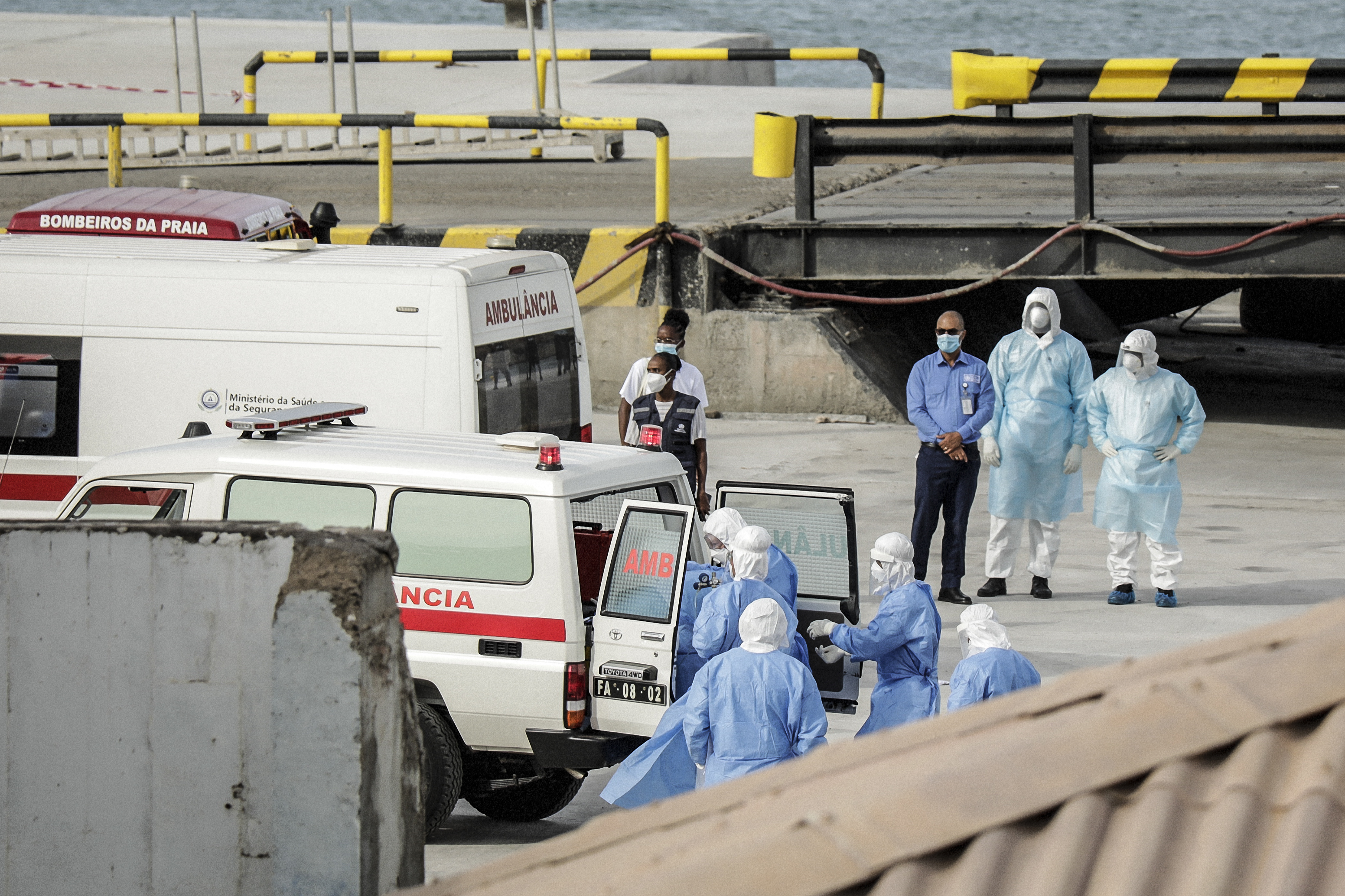 Health personnel returning from the cruise ship MV Hondius, are seen at the port of Praia, the capital of Cape Verde, as individuals wearing hazmat suits are helped into an ambulance on May 6, 2026. | Source: Getty Images