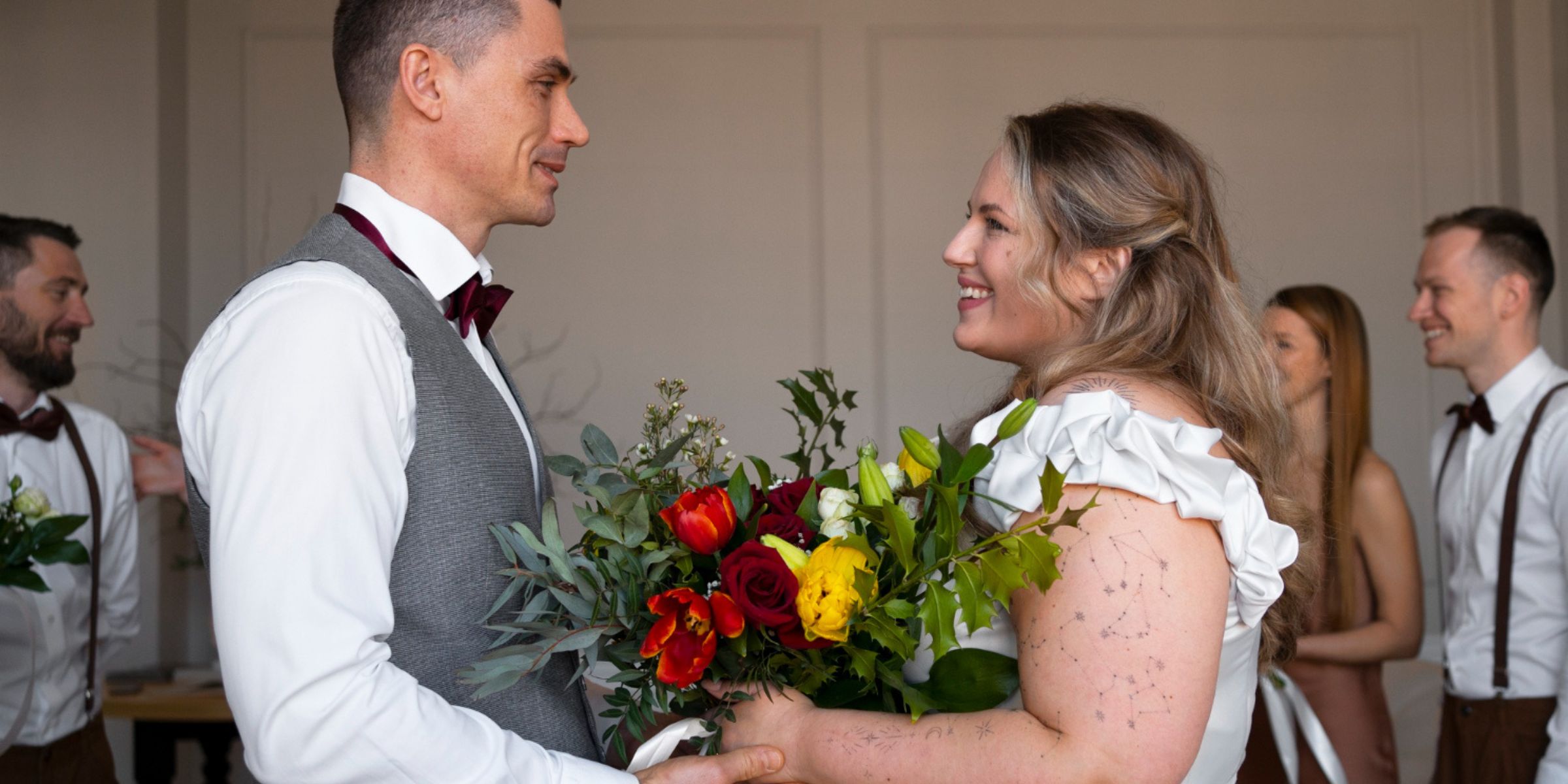 A bride and groom smiling at each other while exchanging flowers during their wedding celebration | Source: No source