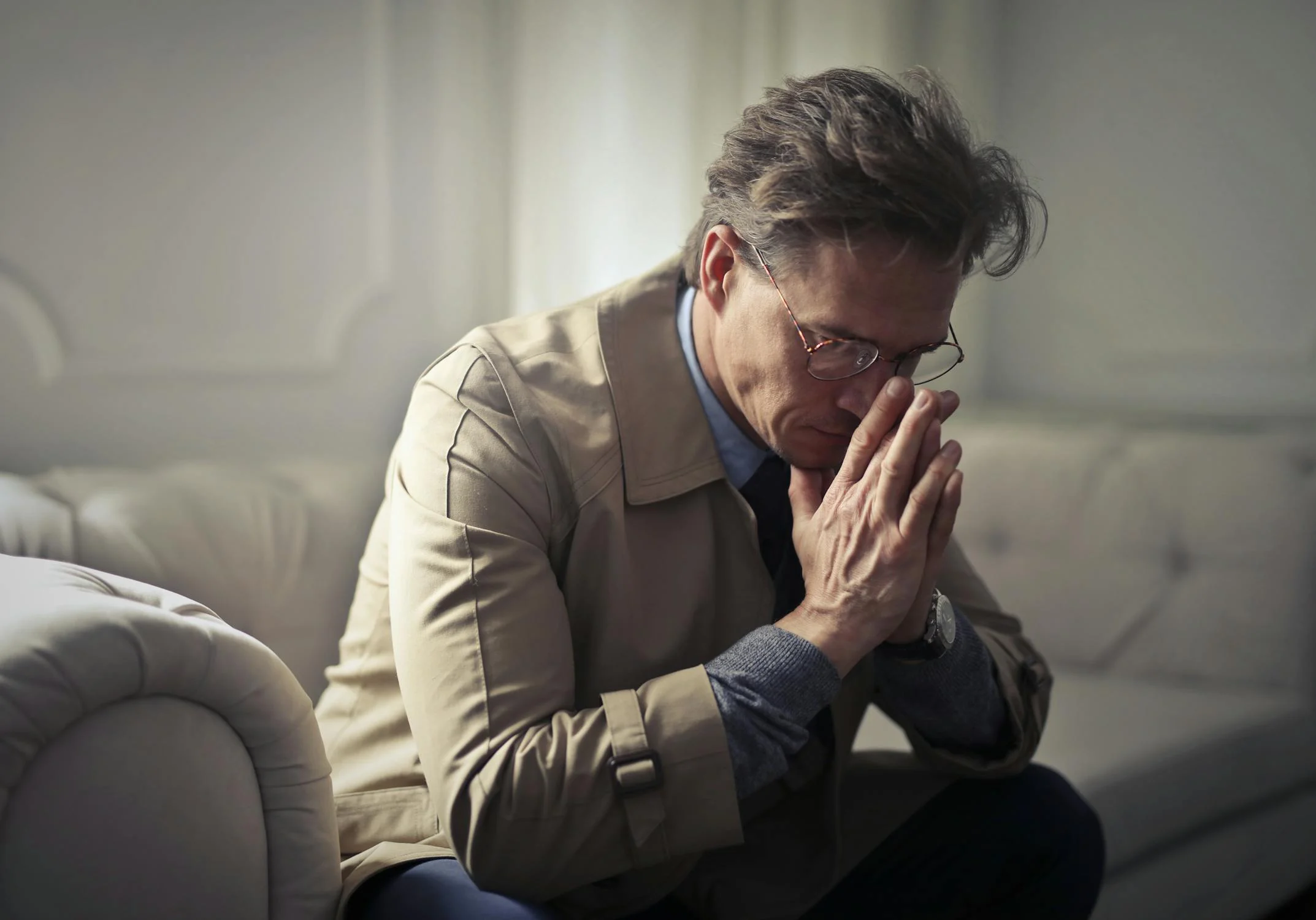 A defeated mature man sitting on a sofa | Source: Pexels