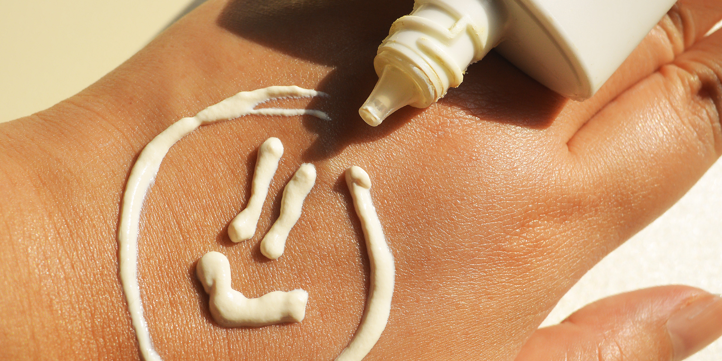A smiley face made with sunscreen lotion | Source: Getty Images