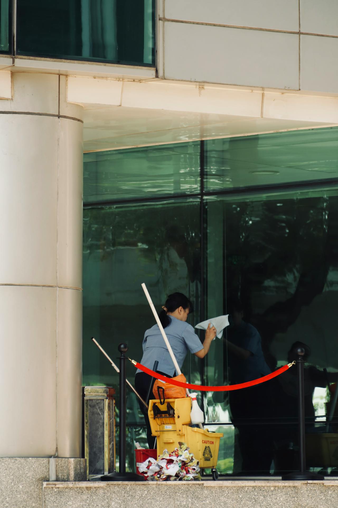 A woman cleaning an office window | Source: Pexels