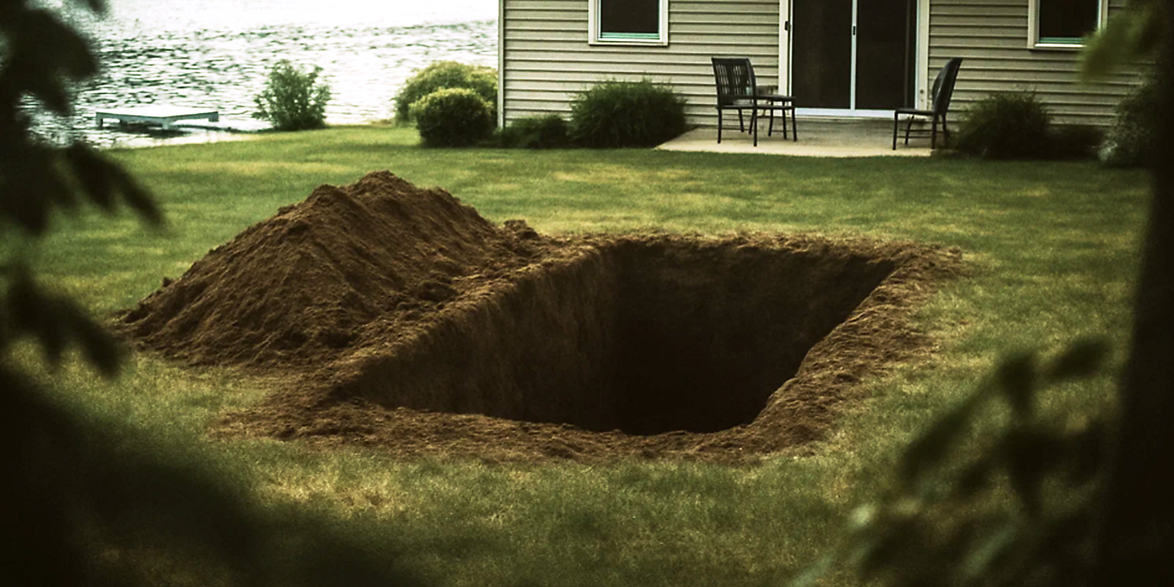 A freshly dug, grave-sized pit behind a lake house | Source: No source