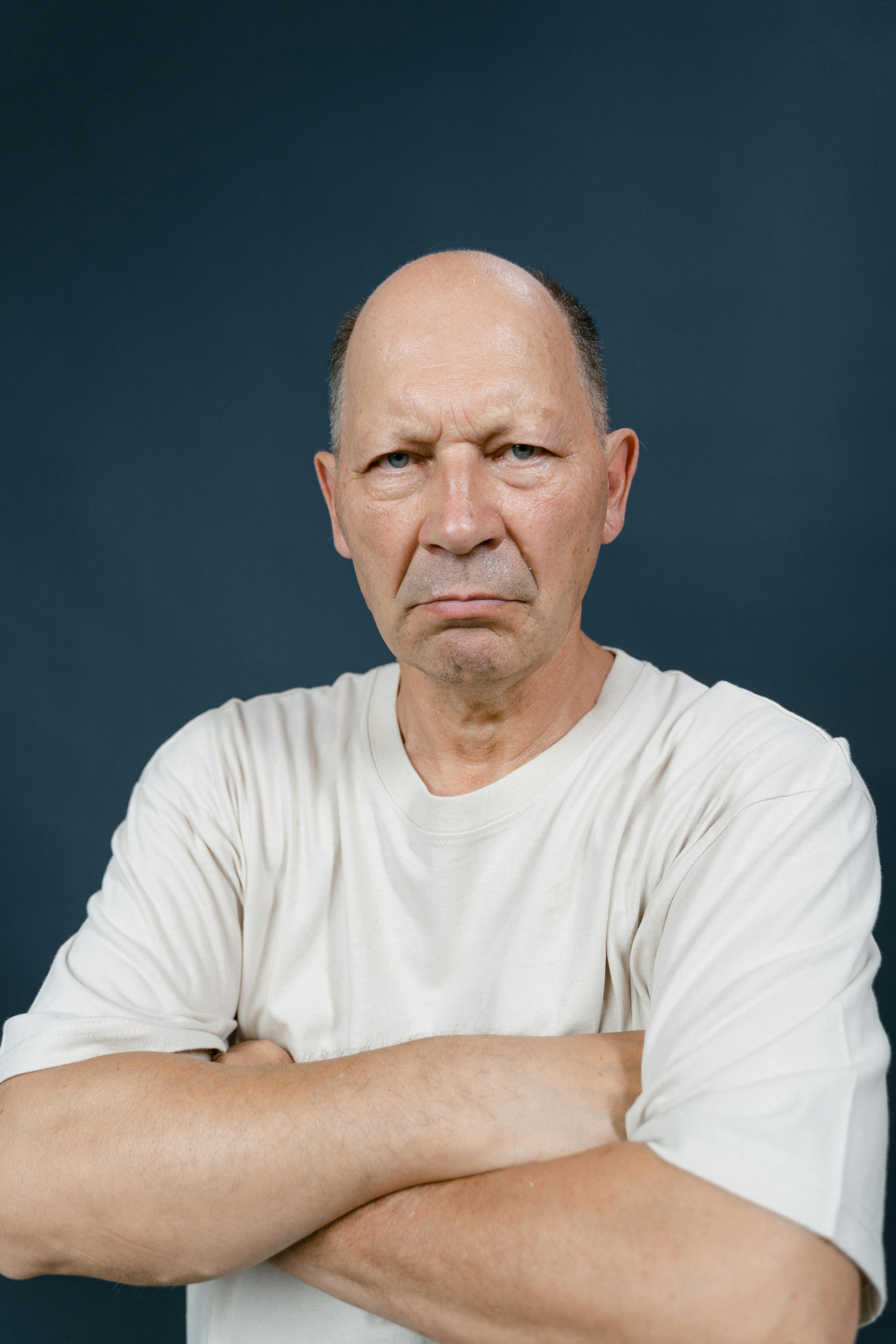 An angry man stanging with arms folded | Source: Pexels