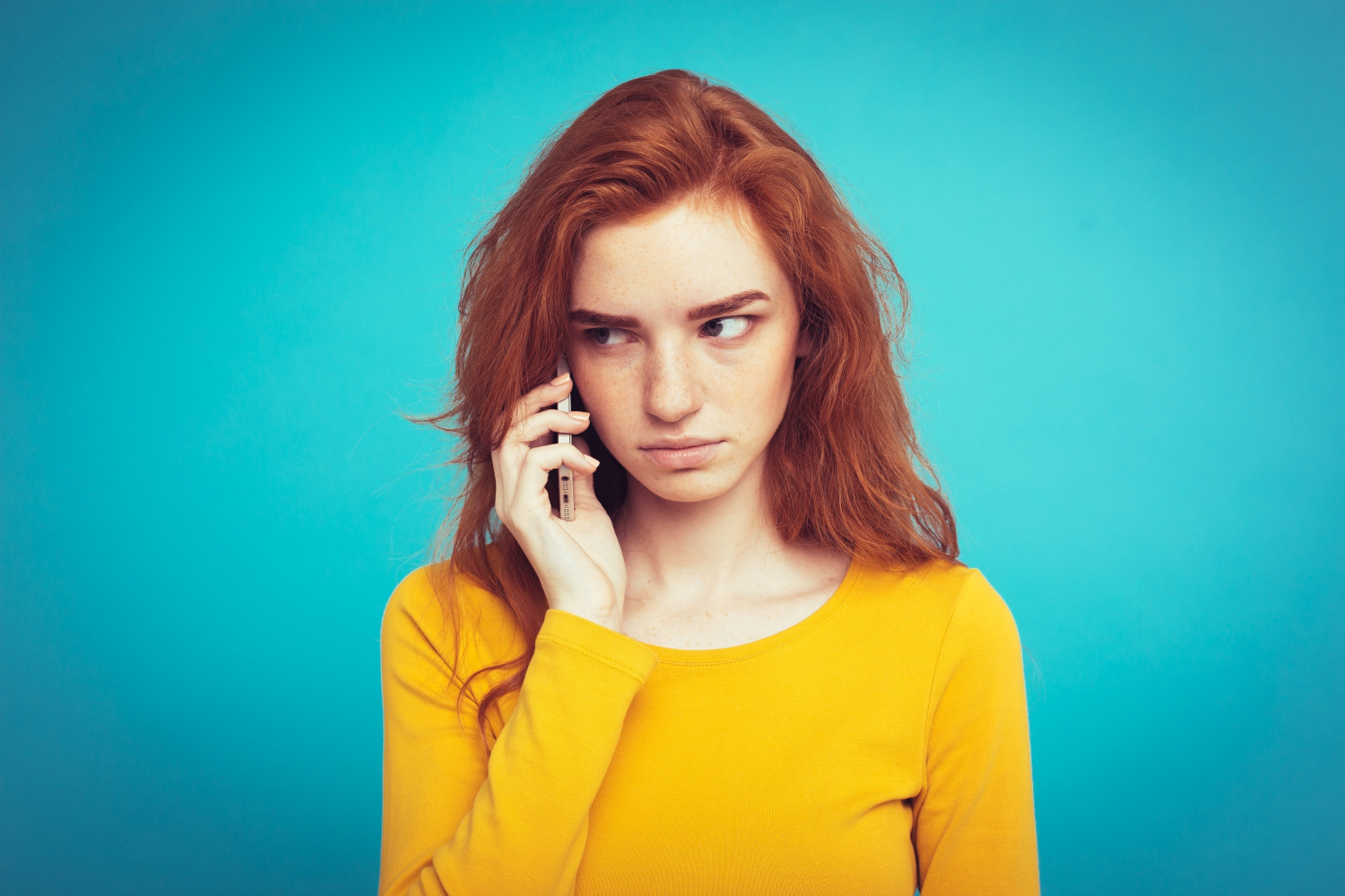 A distressed young woman talking on the phone | Source: Freepik