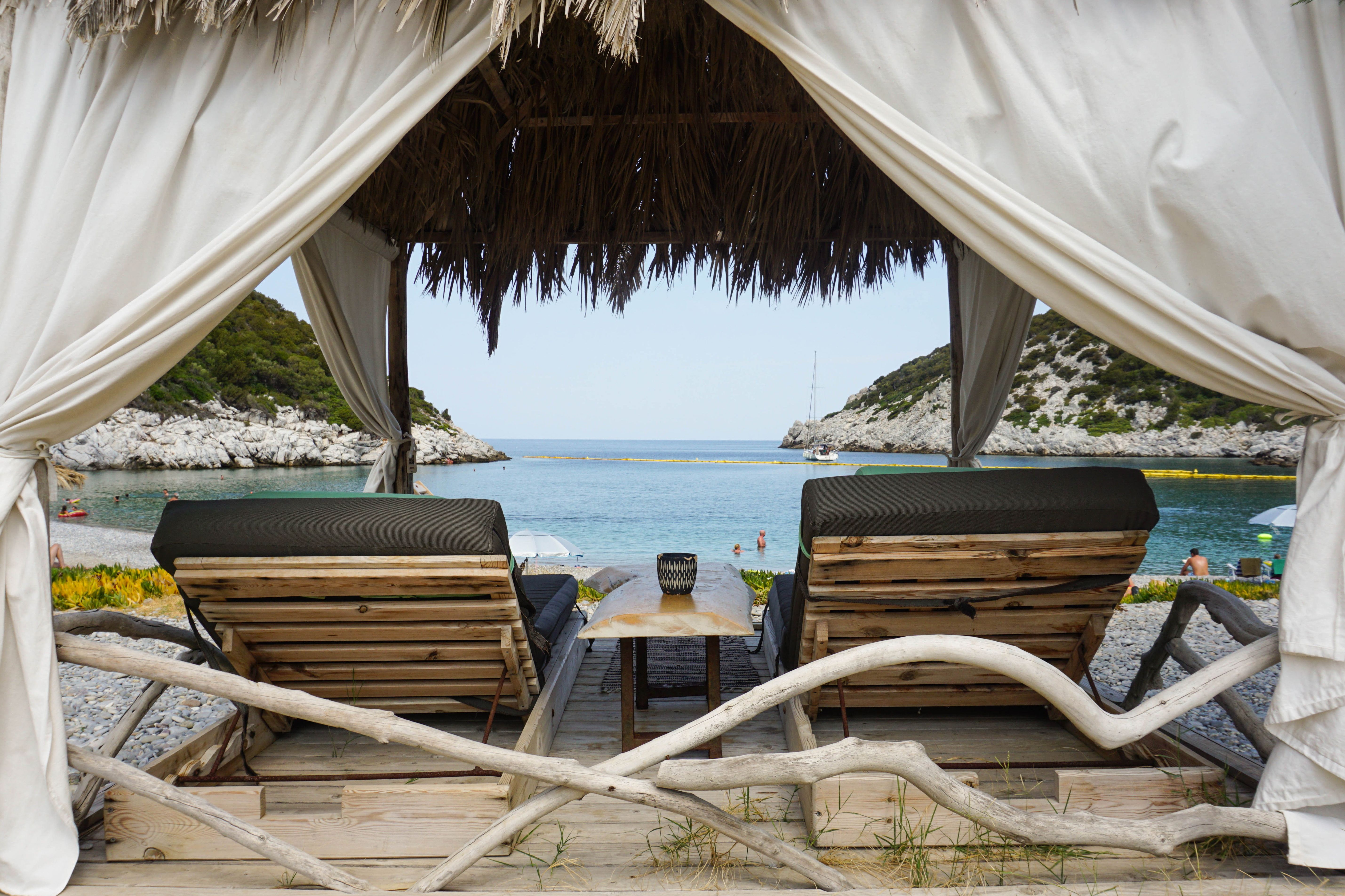 Two pool chairs under a cabana | Source: Pexels