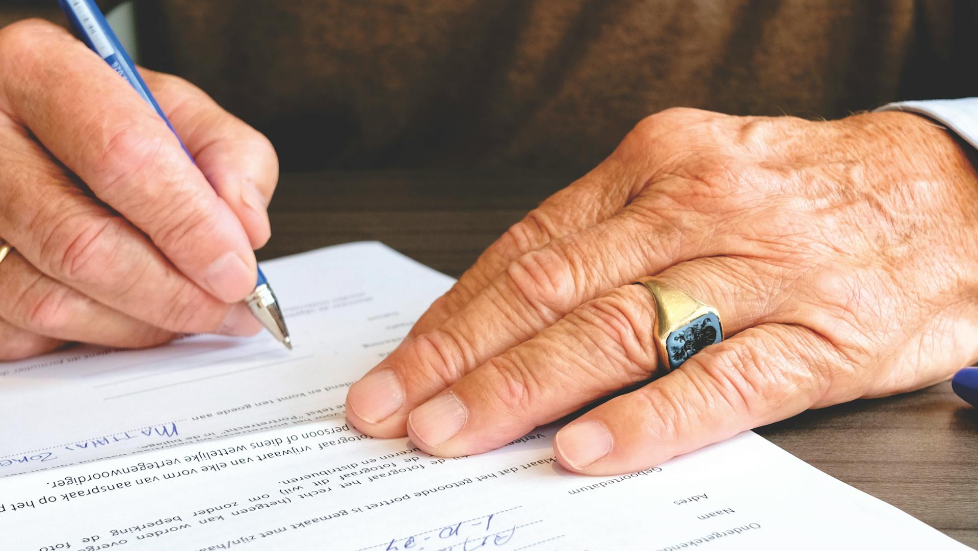 Close-up shot of a senior man signing a document | Source: Pexels