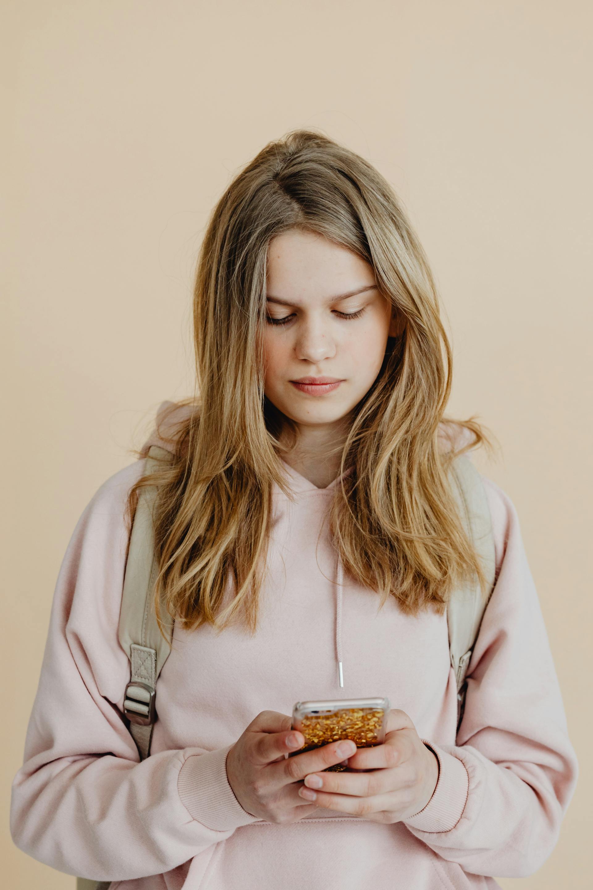 A sad teenage girl looking at her phone | Source: Pexels