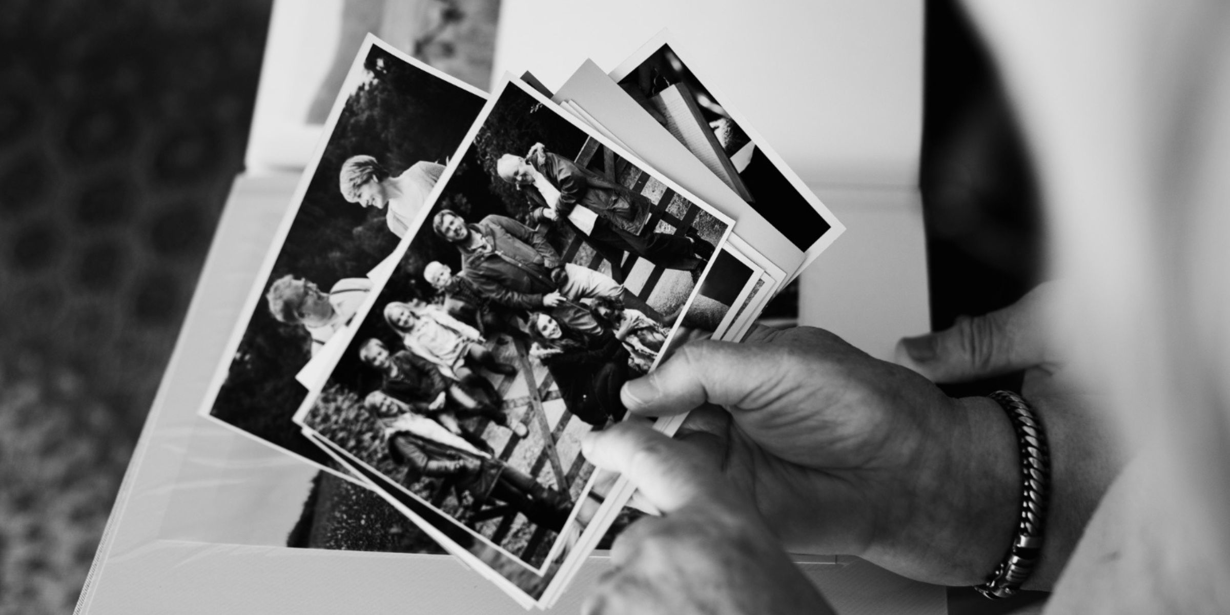 Person looking through a stack of printed photographs | Source: No source