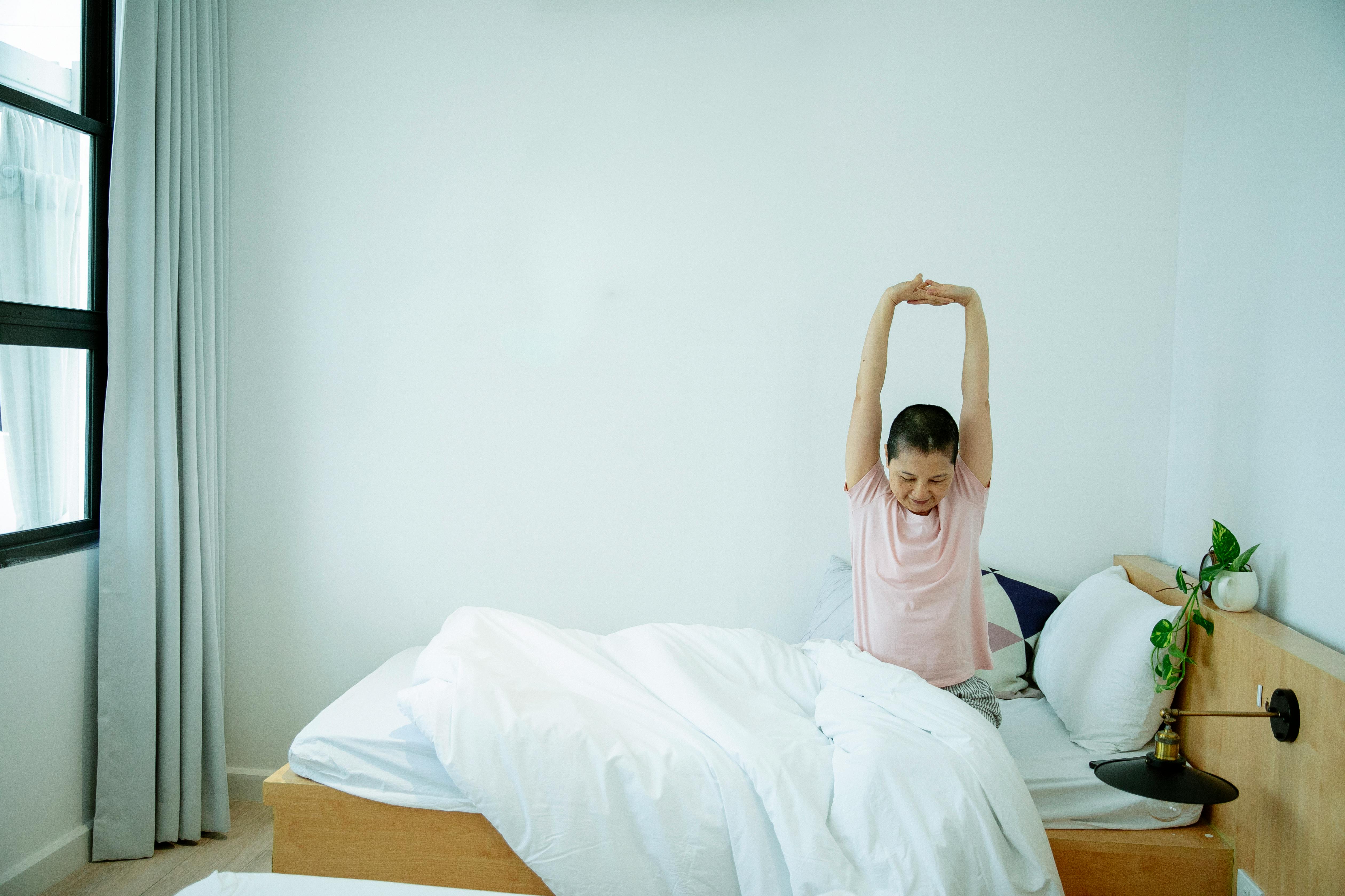 Woman stretching in bed | Source: Pexels