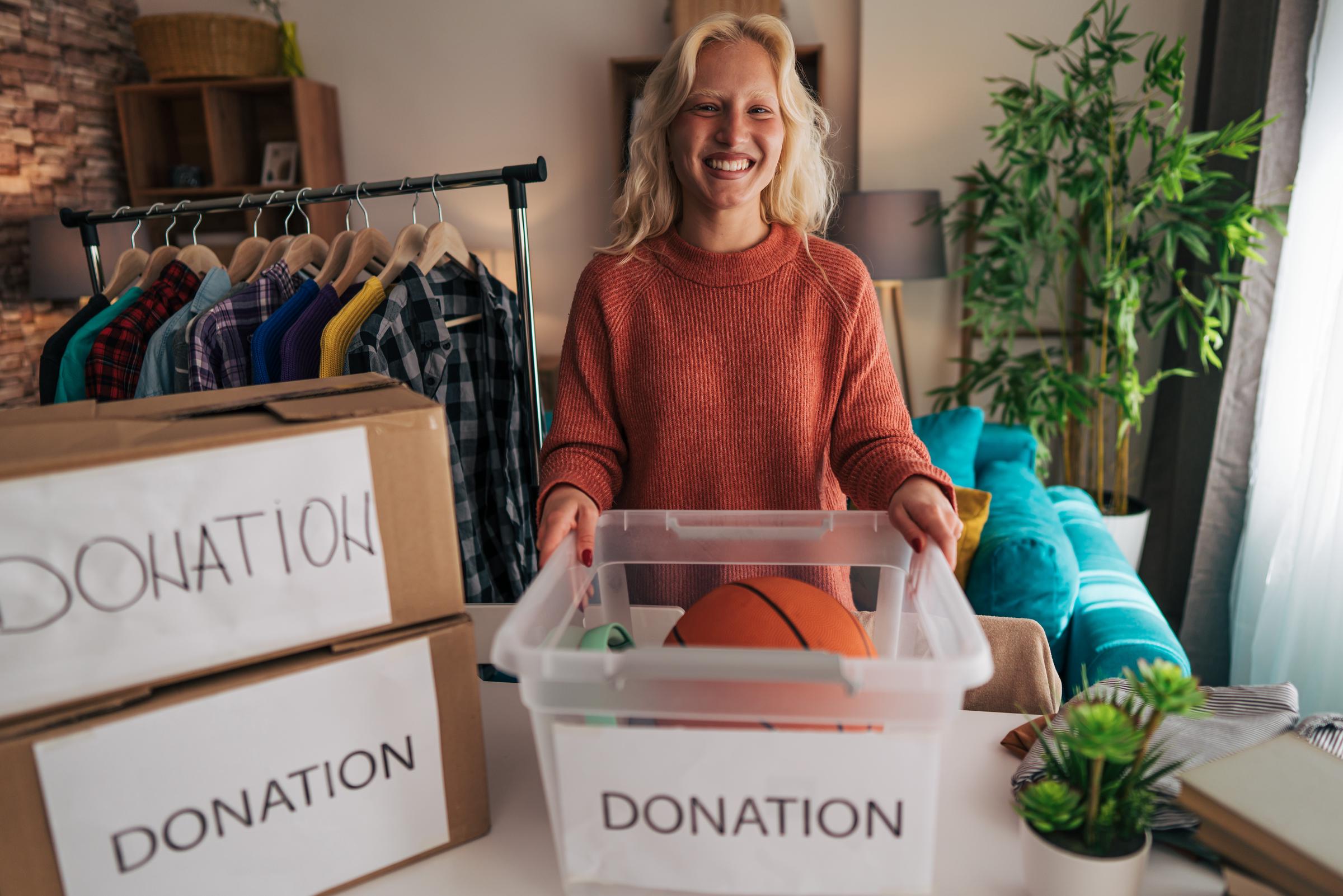 A woman organizes clothes, toys, and other items in donation boxes | Source: Getty Images