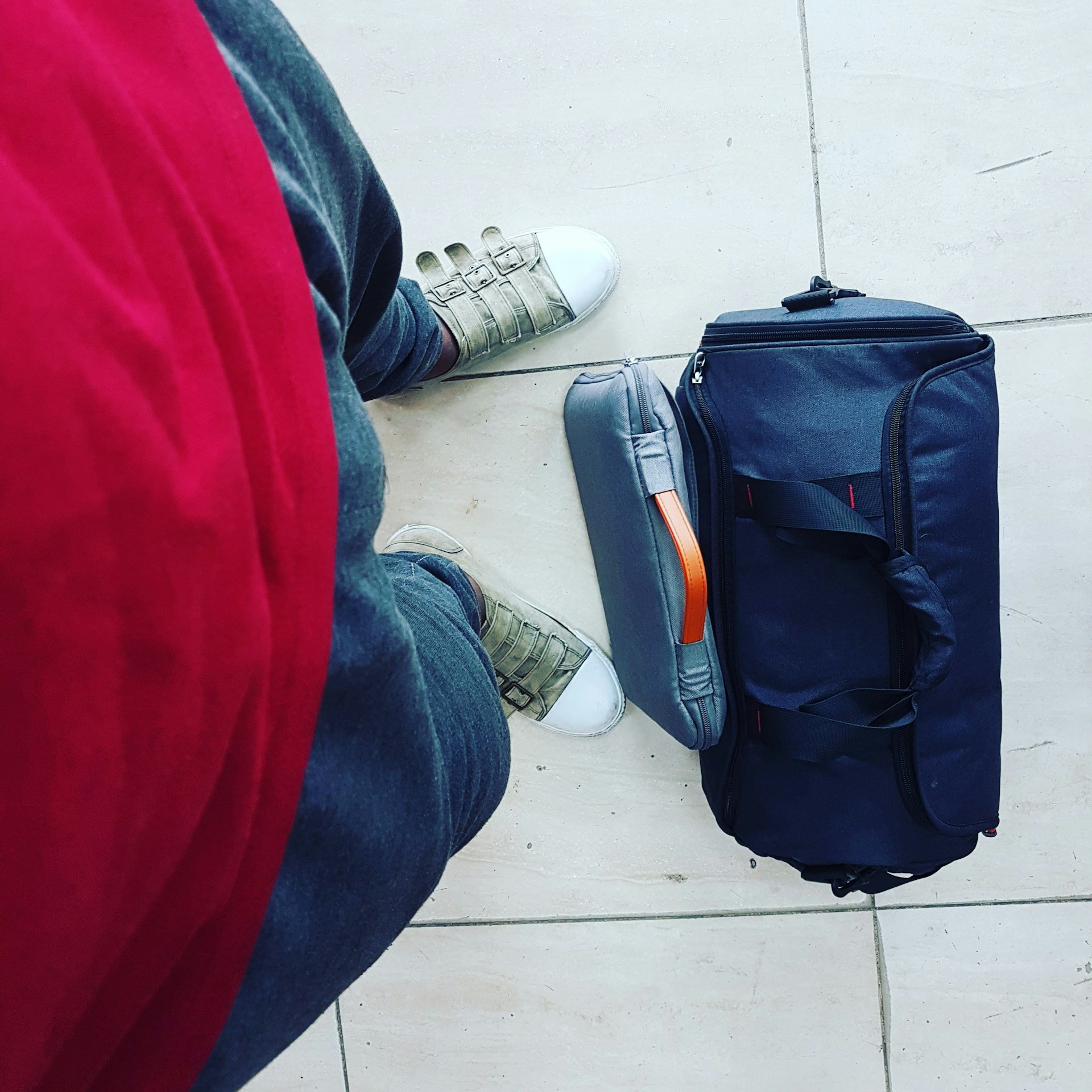 A duffel bag at someone's feet | Source: Unsplash