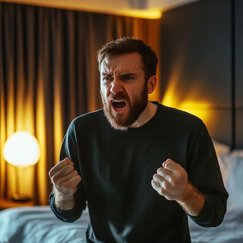 An angry man talking in a hotel room | Source: no source