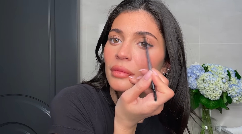 Kylie Jenner doing her classic beauty routine from a video dated April 6, 2023. | Source: YouTube/Vogue