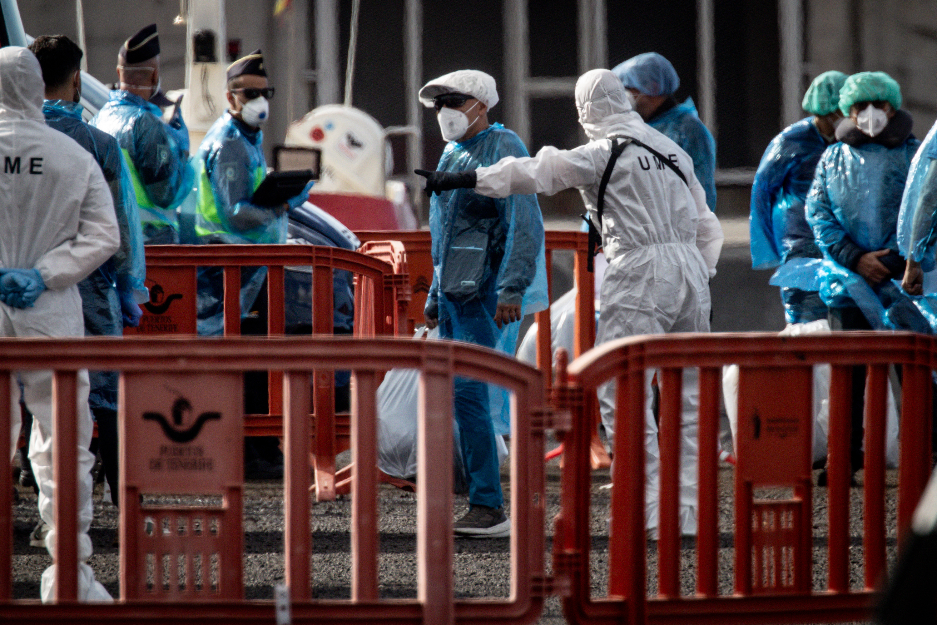 Passengers carry their belongings in plastic bags after being evacuated from the MV Hondius after docking in the Granadilla Port on May 10, 2026 in Tenerife, part of the Canary Islands, Spain. | Source: Getty Images