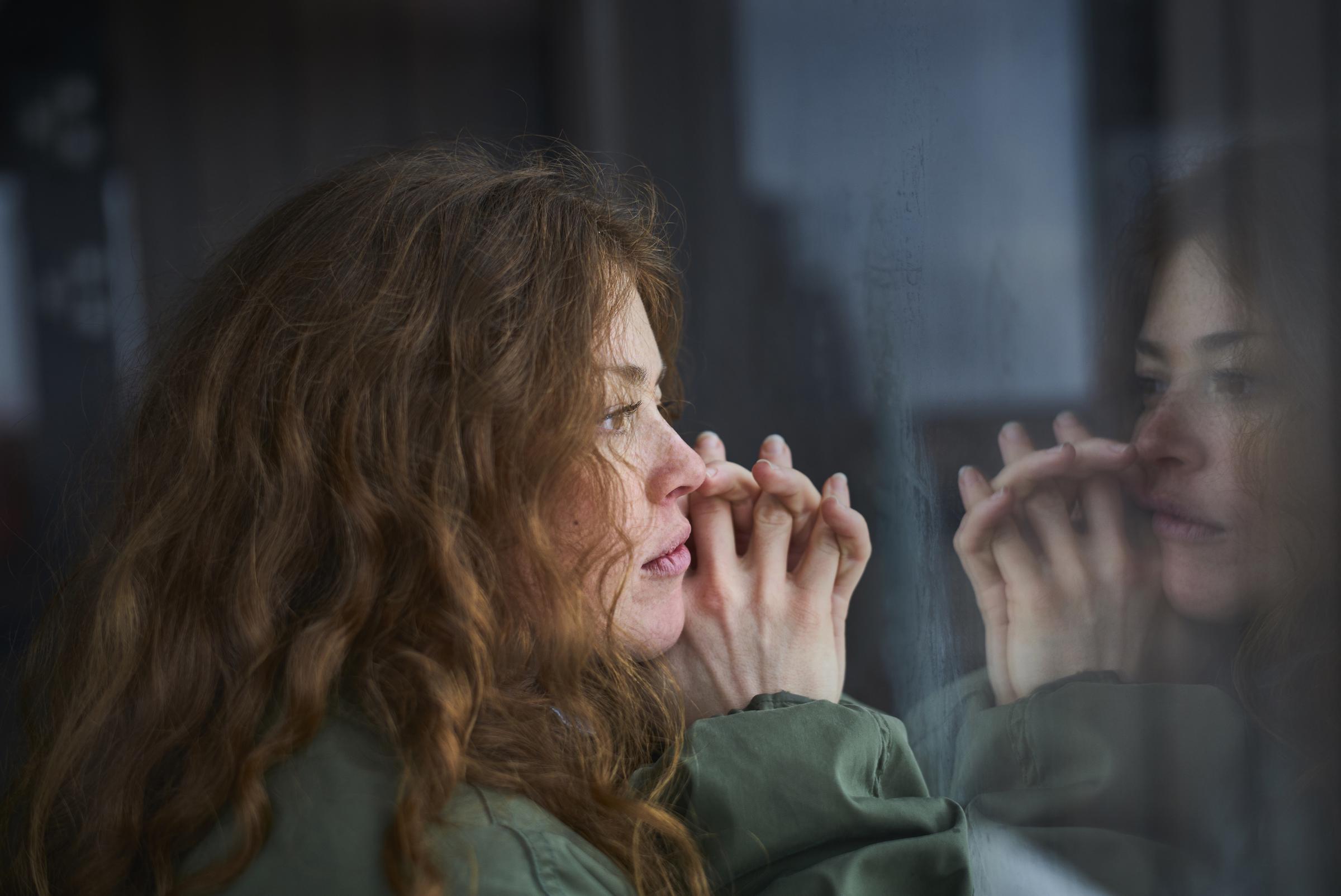 A woman thoughtfully looking out the window | Source: Getty Images