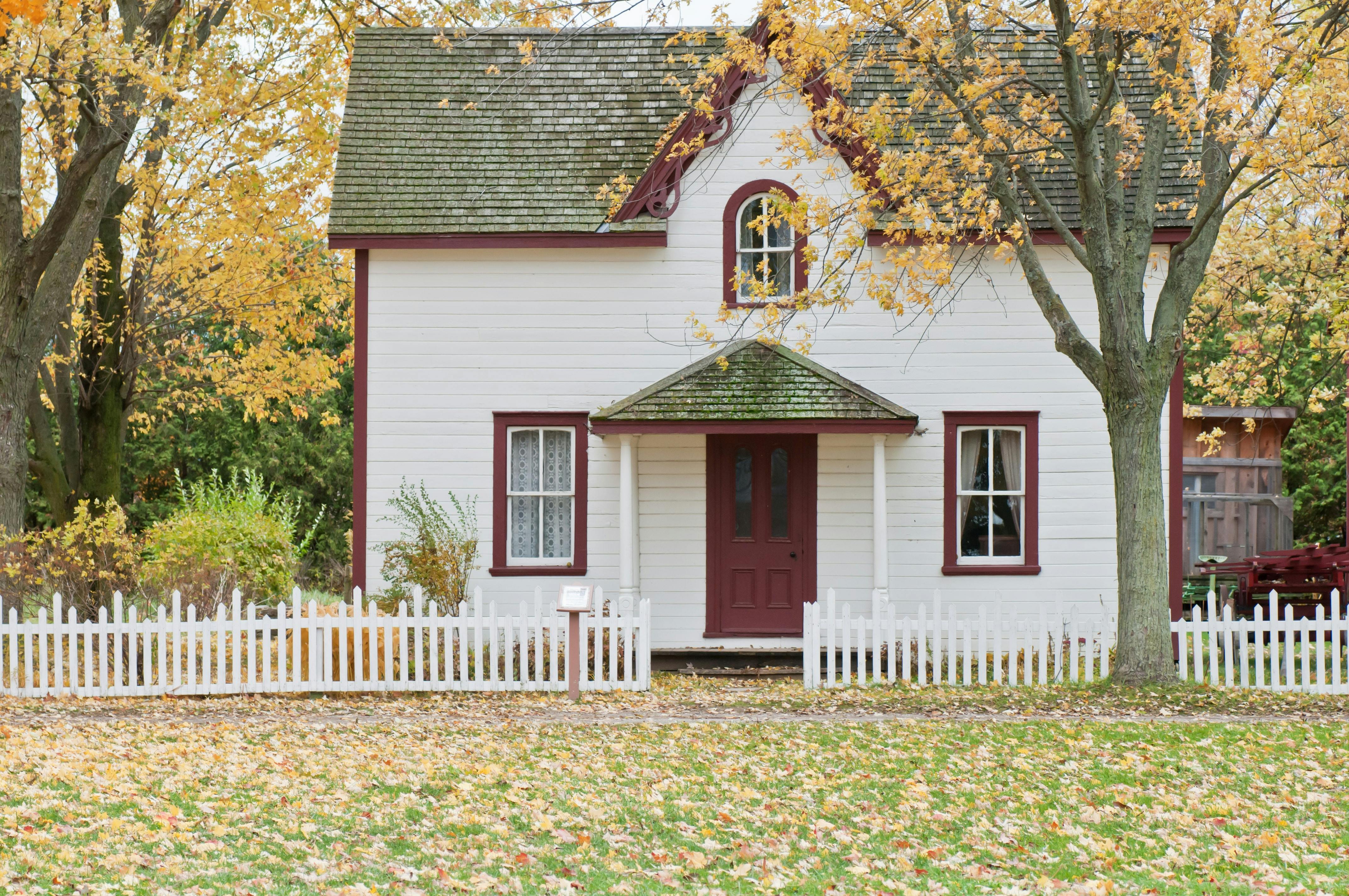 White and red house in old style with a fence | Source: Pexels