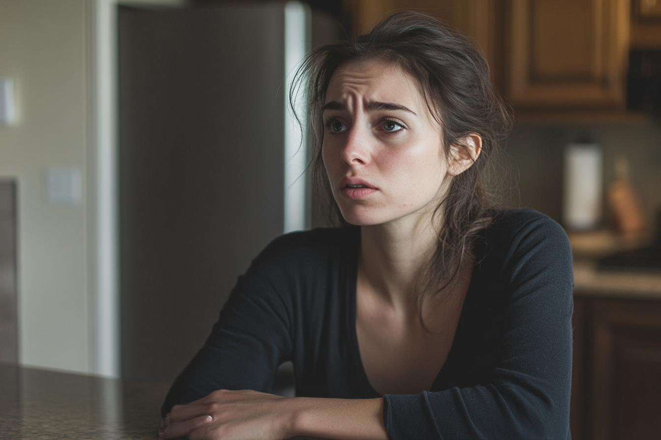A sad and shocked woman seated at kitchen table | Source: No source