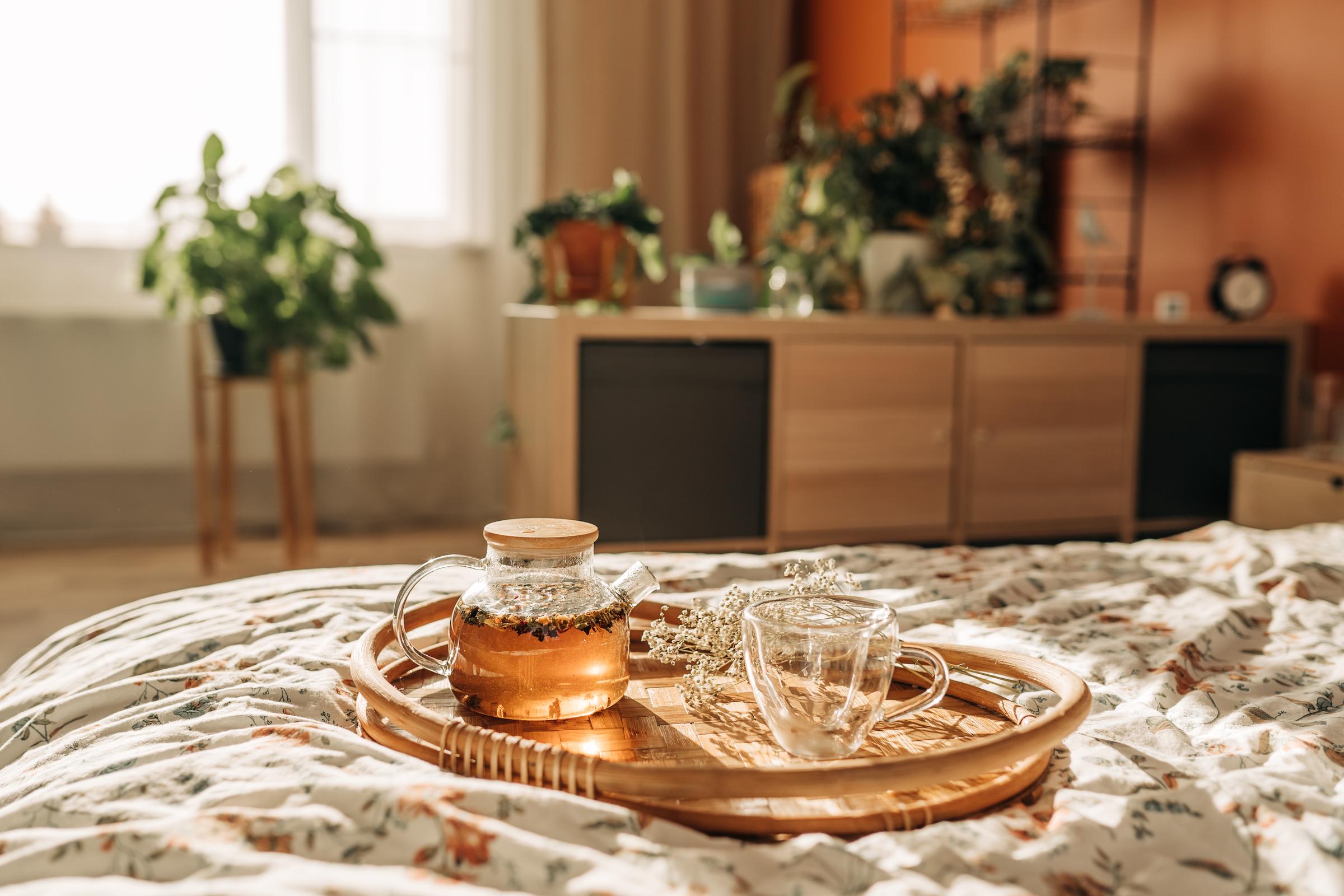 A glass teapot and a mug on a wooden tray | Source: Getty Images