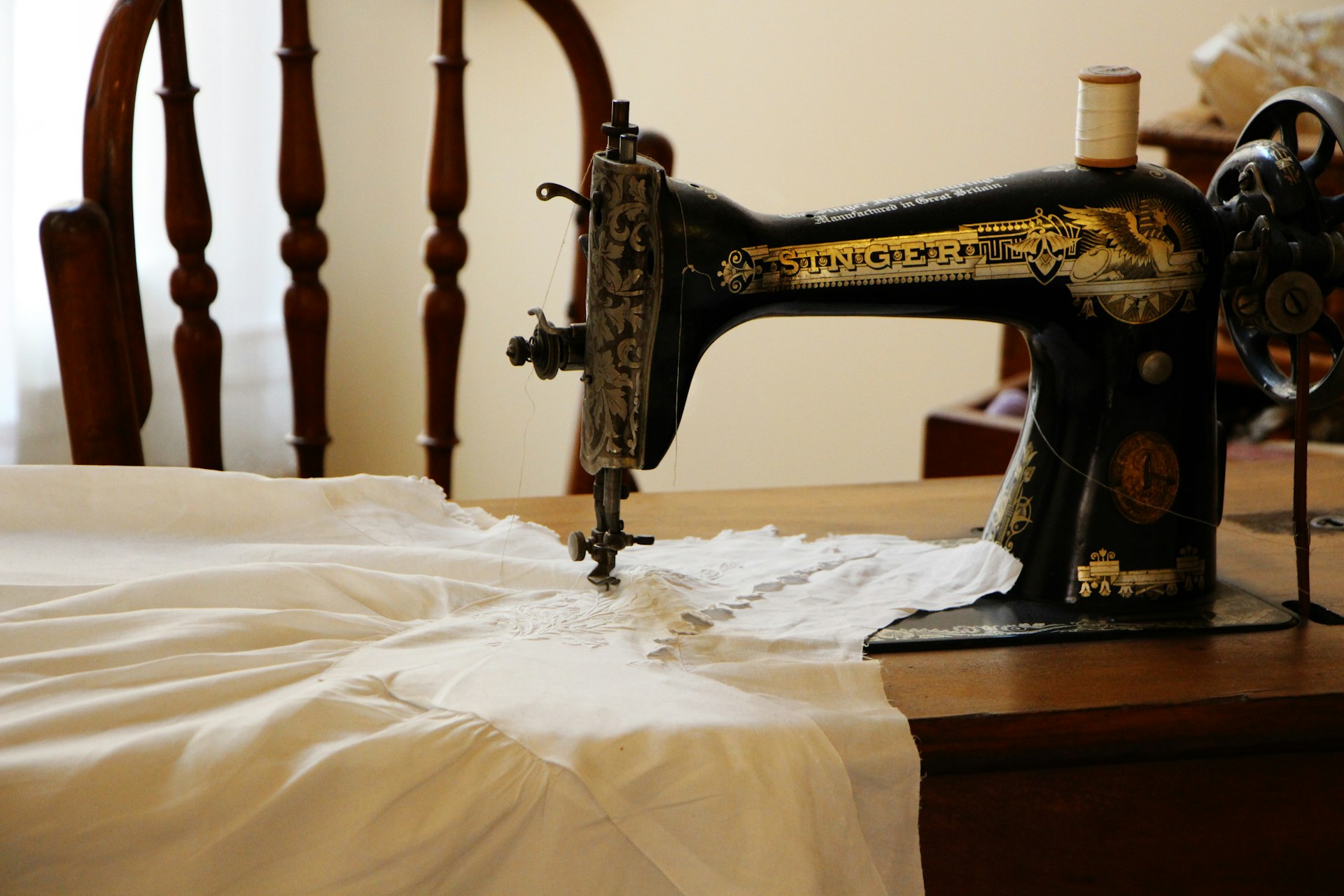 A white garment being stitched using a sewing machine | Source: Unsplash