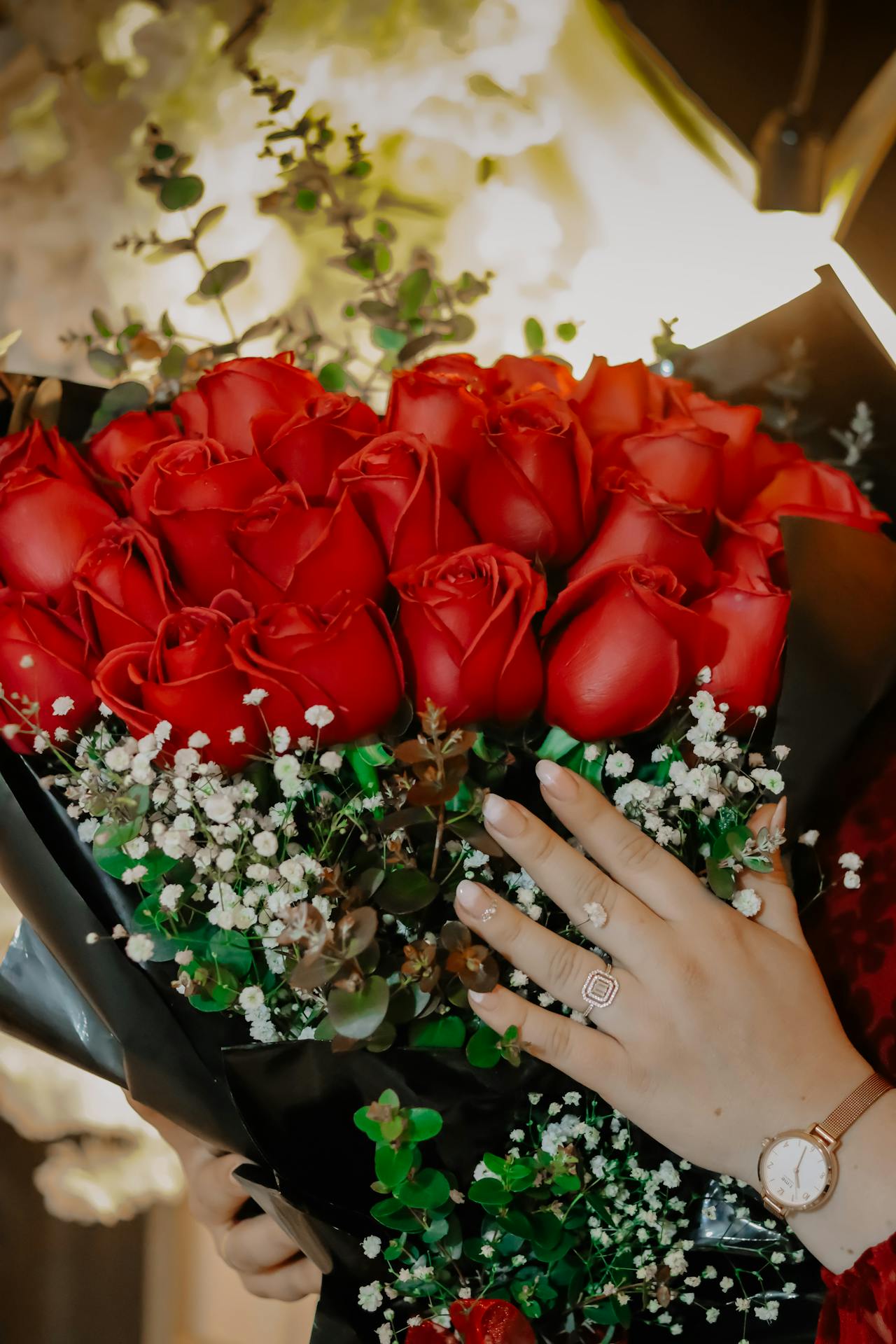 Cropped shot of a woman holding a bouquet of red roses | Source: Pexels
