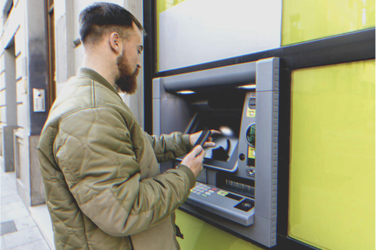 A man withdraws money from an ATM | Source: Getty Images