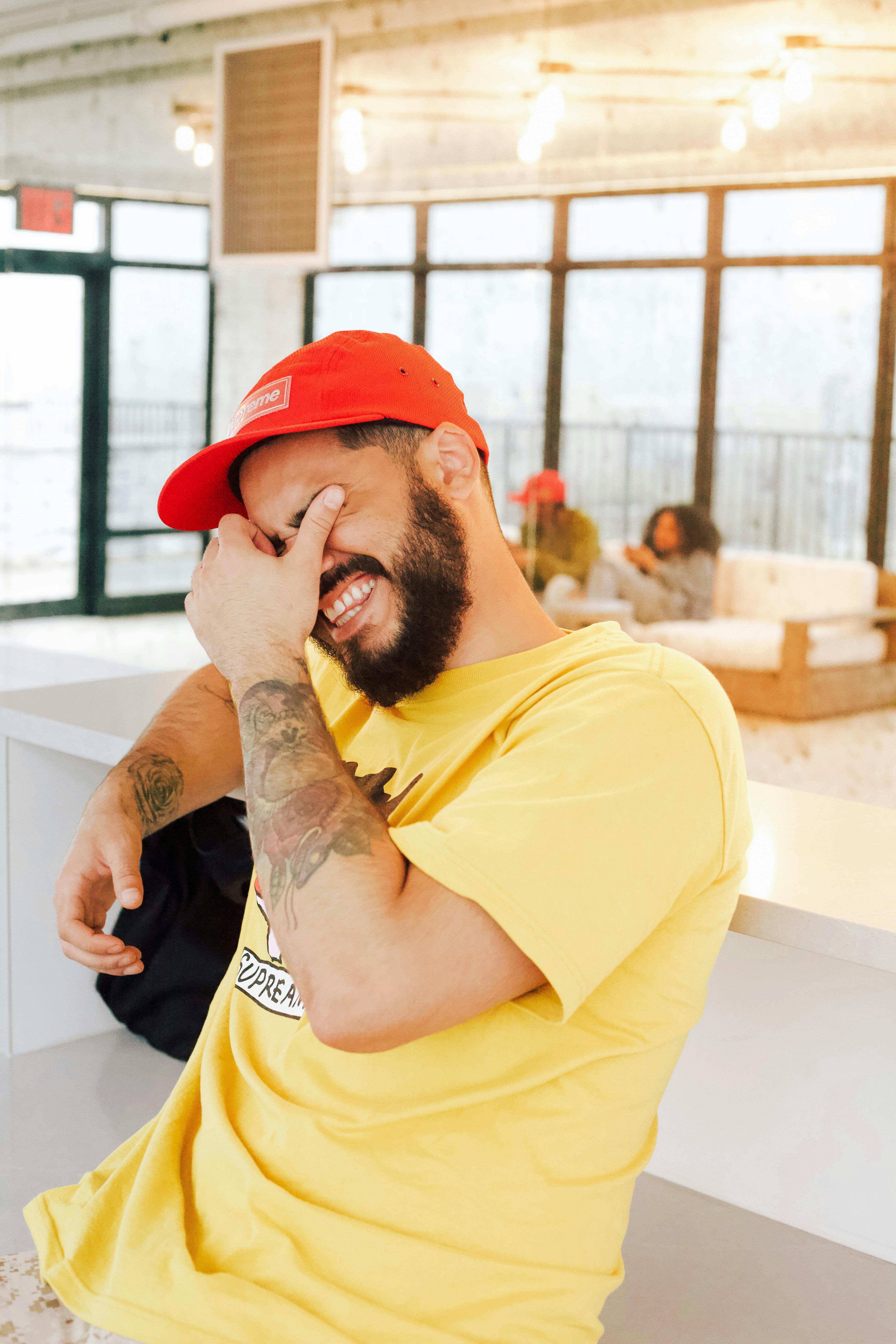A man laughing with his hands covering his eyes | Source: Pexels