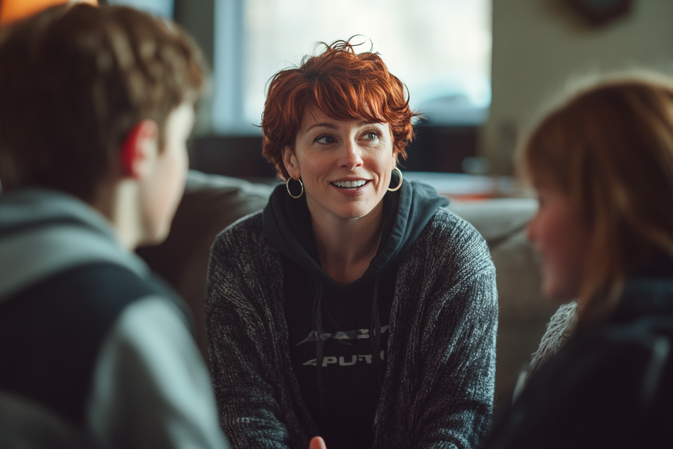 Woman in her 30s talking to her teenage kids on a couch | Source: No source