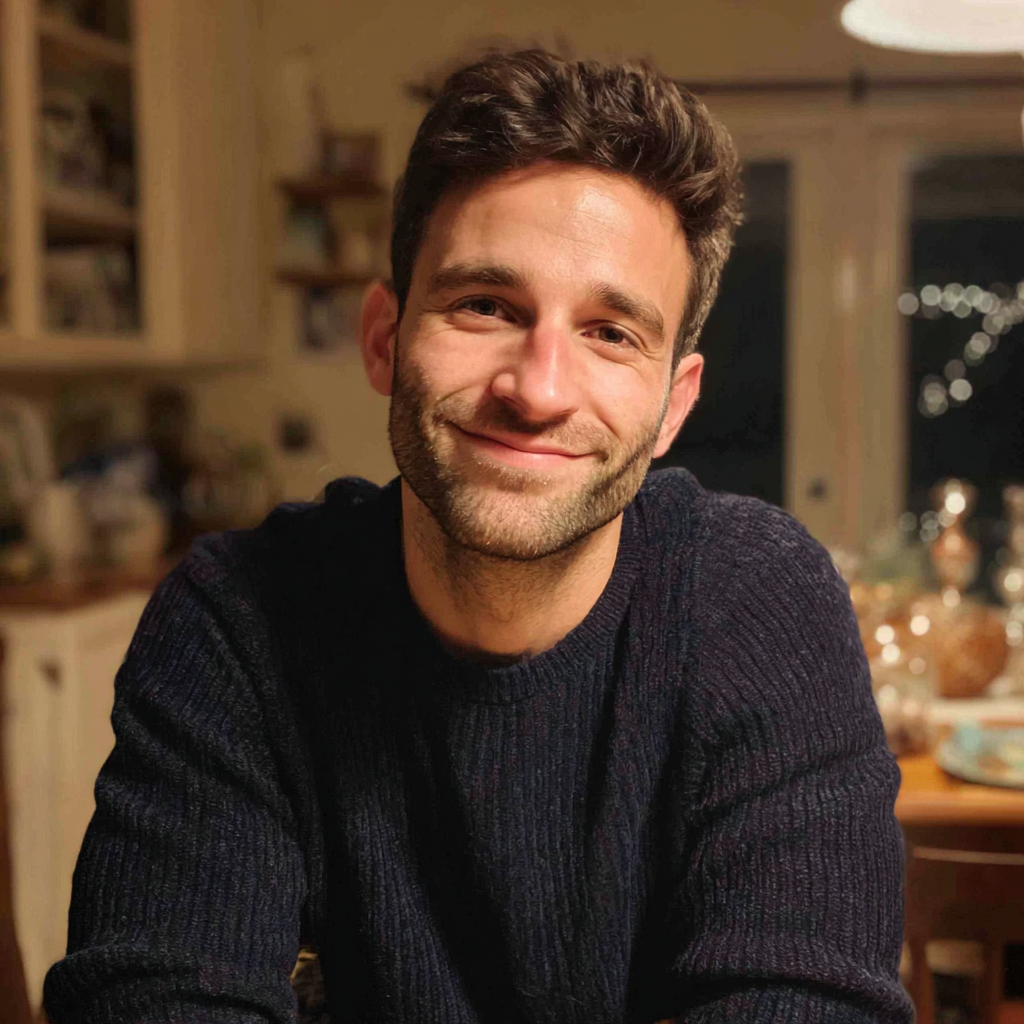 A man sitting at a table wearing a navy sweater | Source: No Source