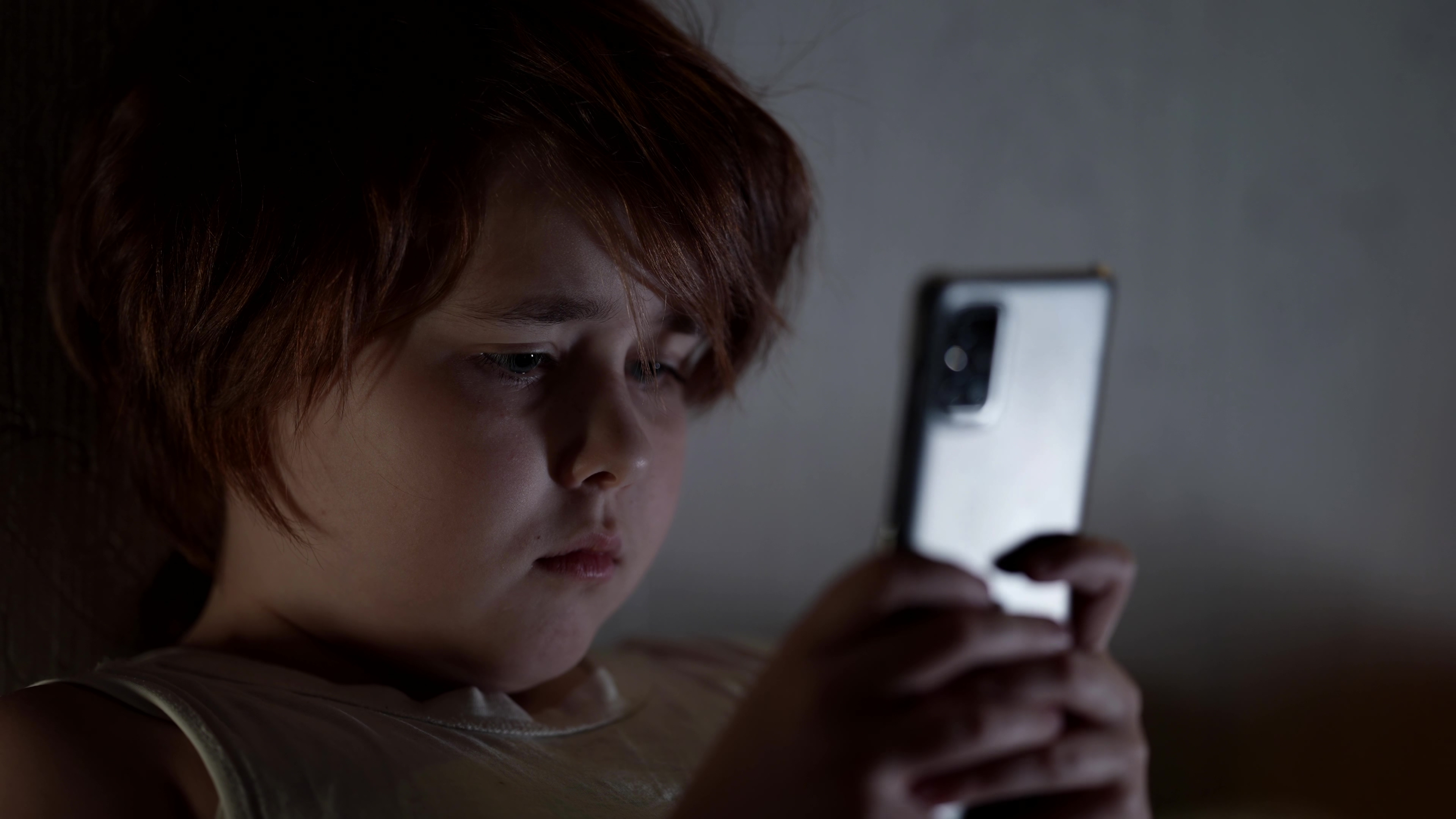 A kid playing on his phone in the dark | Source: Shutterstock